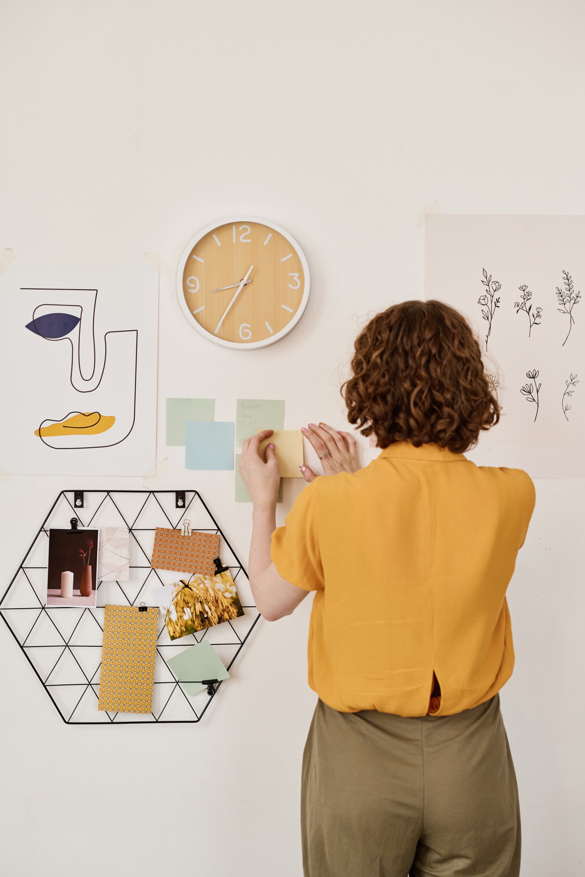 Designer arranging concept notes and a moodboard on a wall